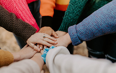 A team stacking there hands in the center of the group.