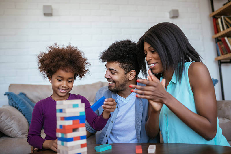 Couple plays with daughter in living room of their newly purchased home.