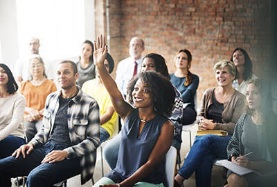 A room of individuals actively watching a presentation