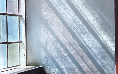 Sunlight shining through a window onto a white interior wall.