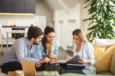 Couple signing a document with another person