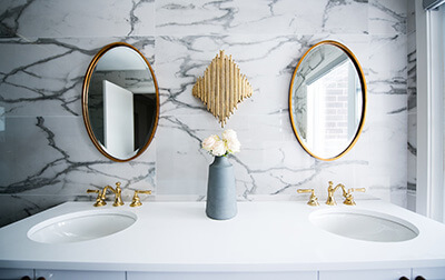 A double vanity with a marble backsplash and white countertop.