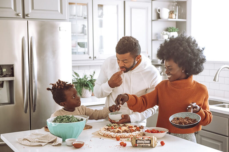 A family making a pizza in their renovated kitchen