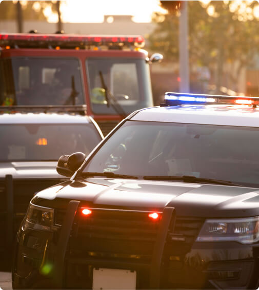 Emergency vehicles at scene, including two police cars and an ambulance