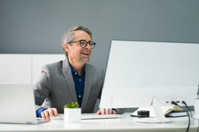 Man sitting at desk identifies a scam on his computer.