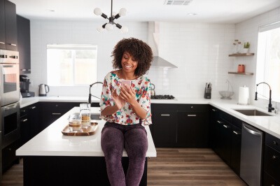 Woman on her phone in the kitchen