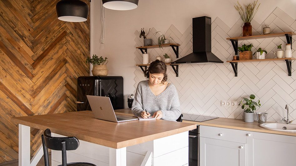 A woman sitting at her counter taking notes from the Cardinali Team's blogs