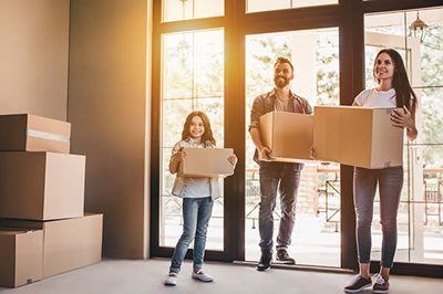 Happy family with cardboard boxes in new house at moving day